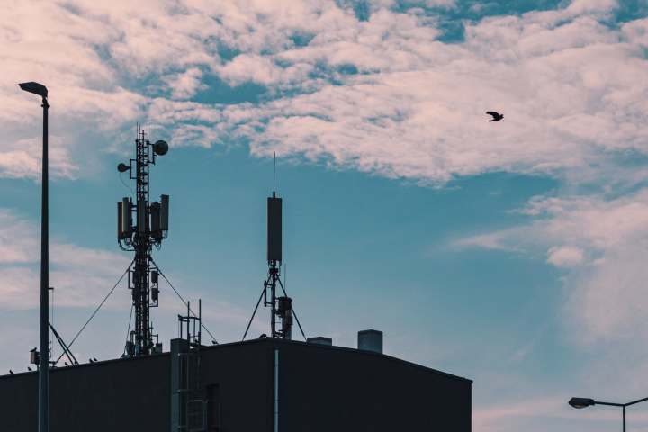 alt: Cellular towers on a building rooftop.