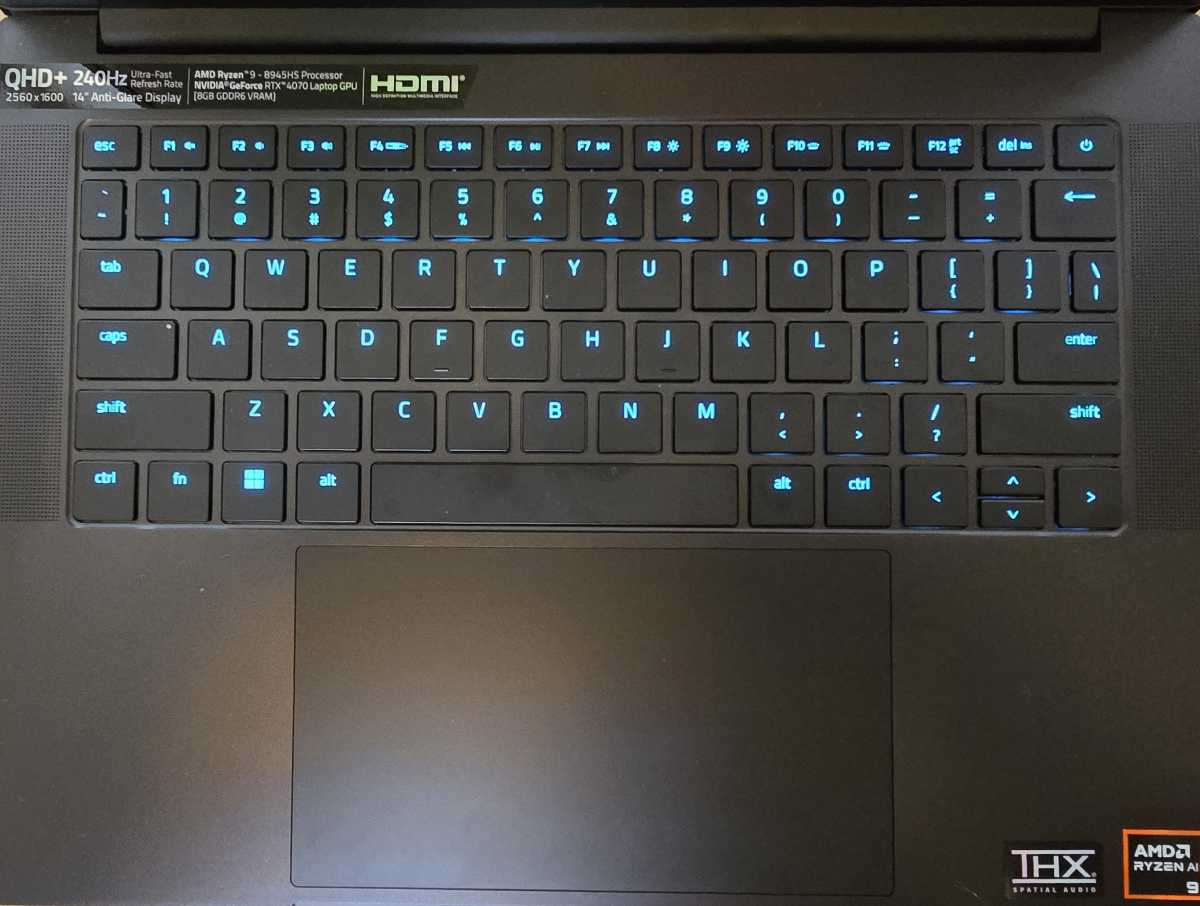 alt text: The Razer Blade 14 keyboard illuminated with a blue backlight, showcasing its per-key RGB customization.