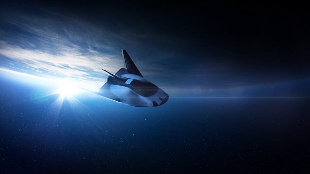 alt text: An artist's impression of the Dream Chaser spaceplane in orbit.  It shows the vehicle with its wings deployed and solar panels extended.