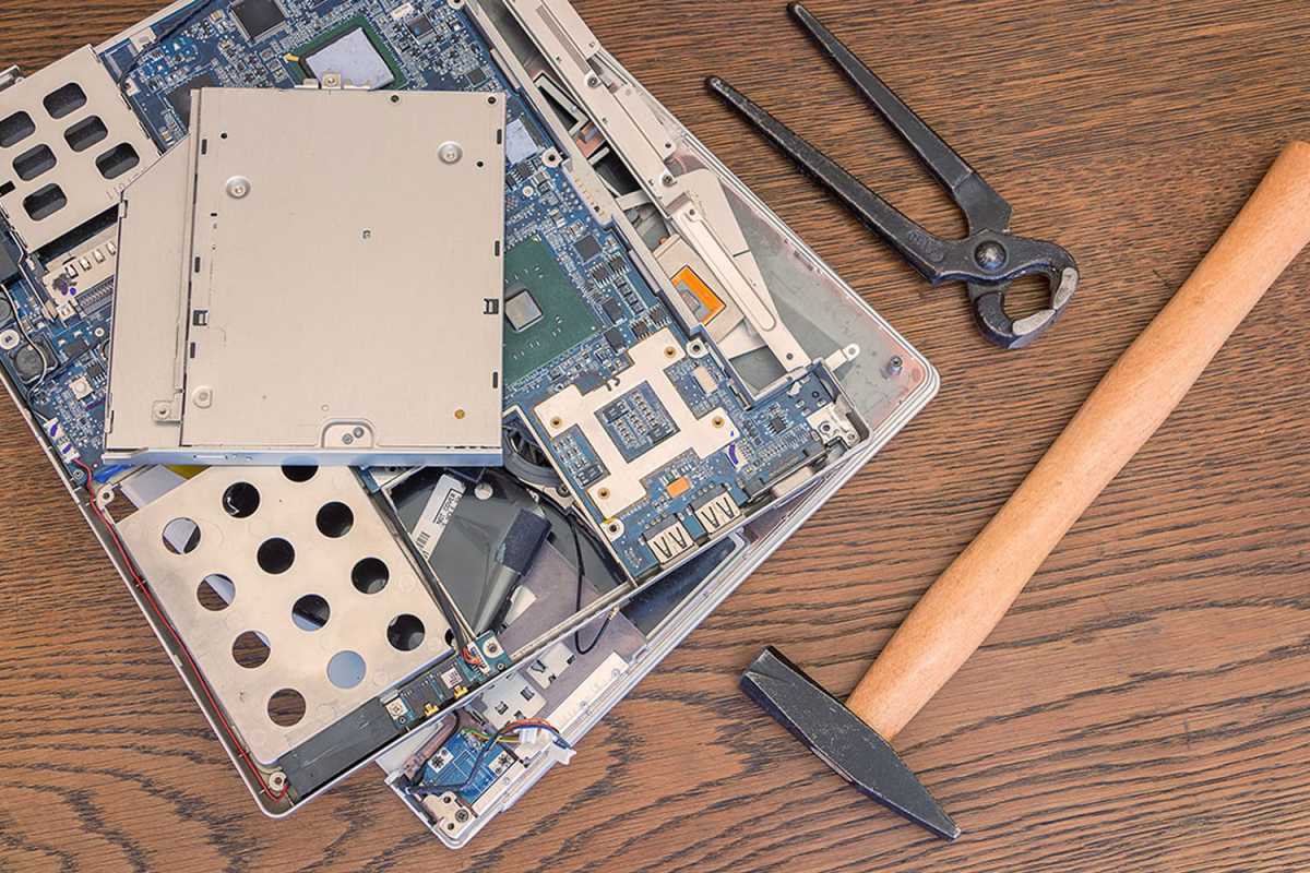 Hammer with broken laptop exposed with all internal components spilling out