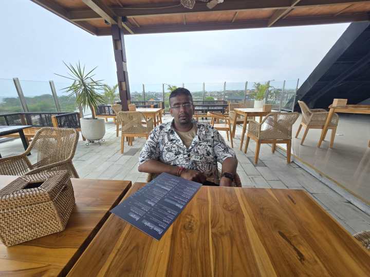 An original photo of a person at a table with a menu in front of them