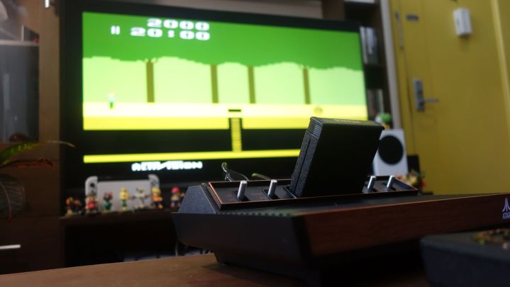 An Atari 2600+ sits on a table running Pitfall.