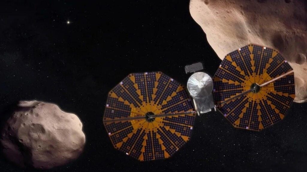 alt text: An artist's rendering of the Lucy spacecraft approaching the asteroid Donaldjohanson. The asteroid is depicted as a dark, irregularly shaped body against the backdrop of space.