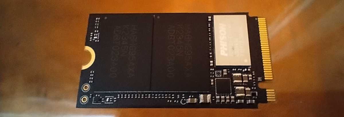 alt text: Close-up view of the Corsair MP600 Micro SSD with its label removed, revealing the underlying components and circuitry.