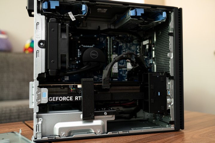 alt text: A person working on a computer with the side panel open, exposing the motherboard.