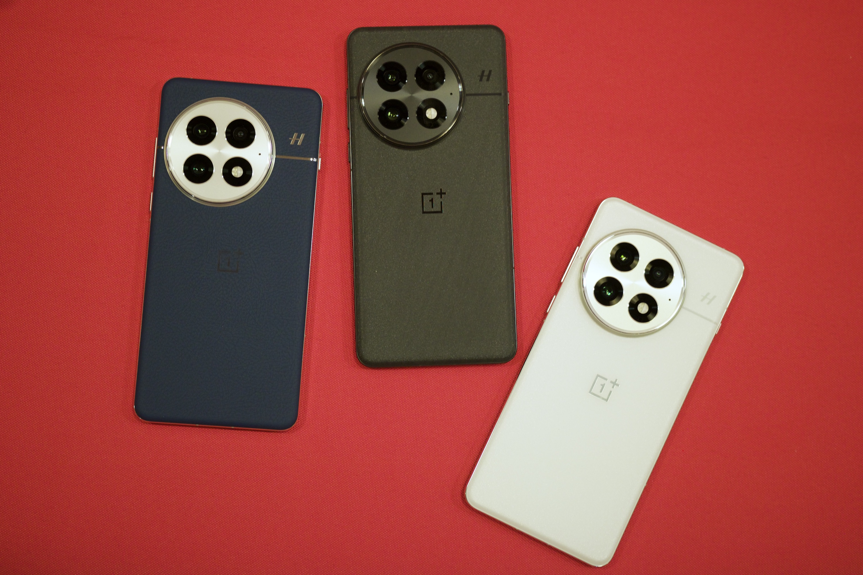 Three OnePlus 13 smartphones next to each other, showing all three colors.