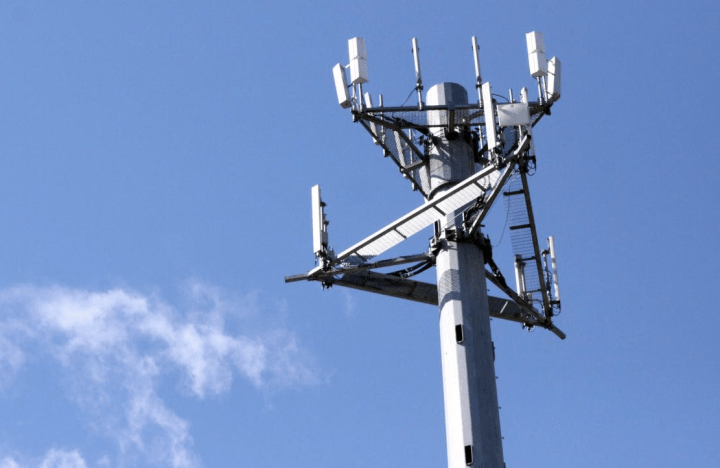 alt: A 4G/5G cellular tower against a blue sky.