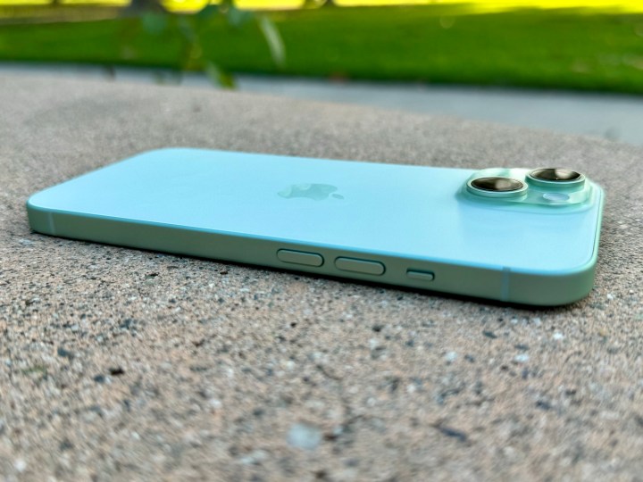 Side view of green iPhone 15 laying flat.