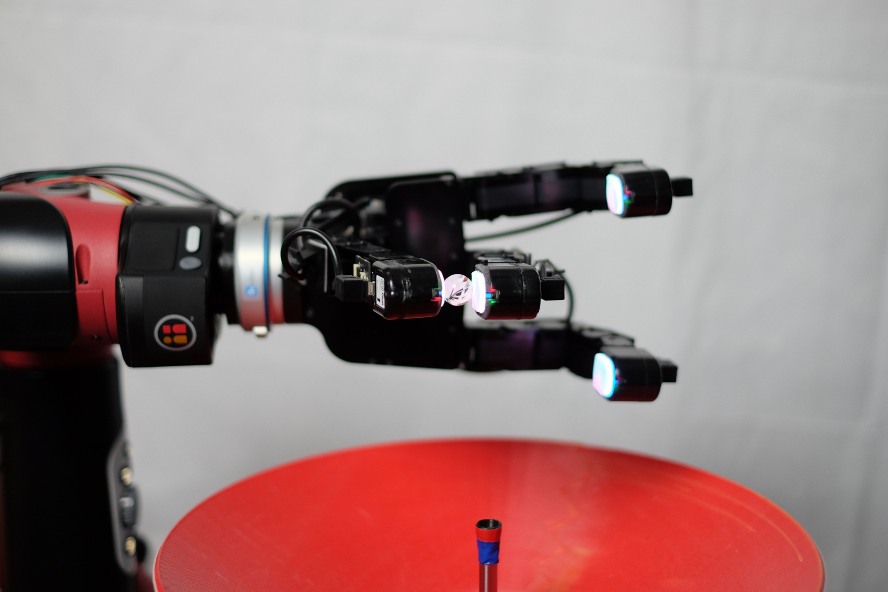 DIGIT sensors mounted on a robot hand manipulating glass marbles.