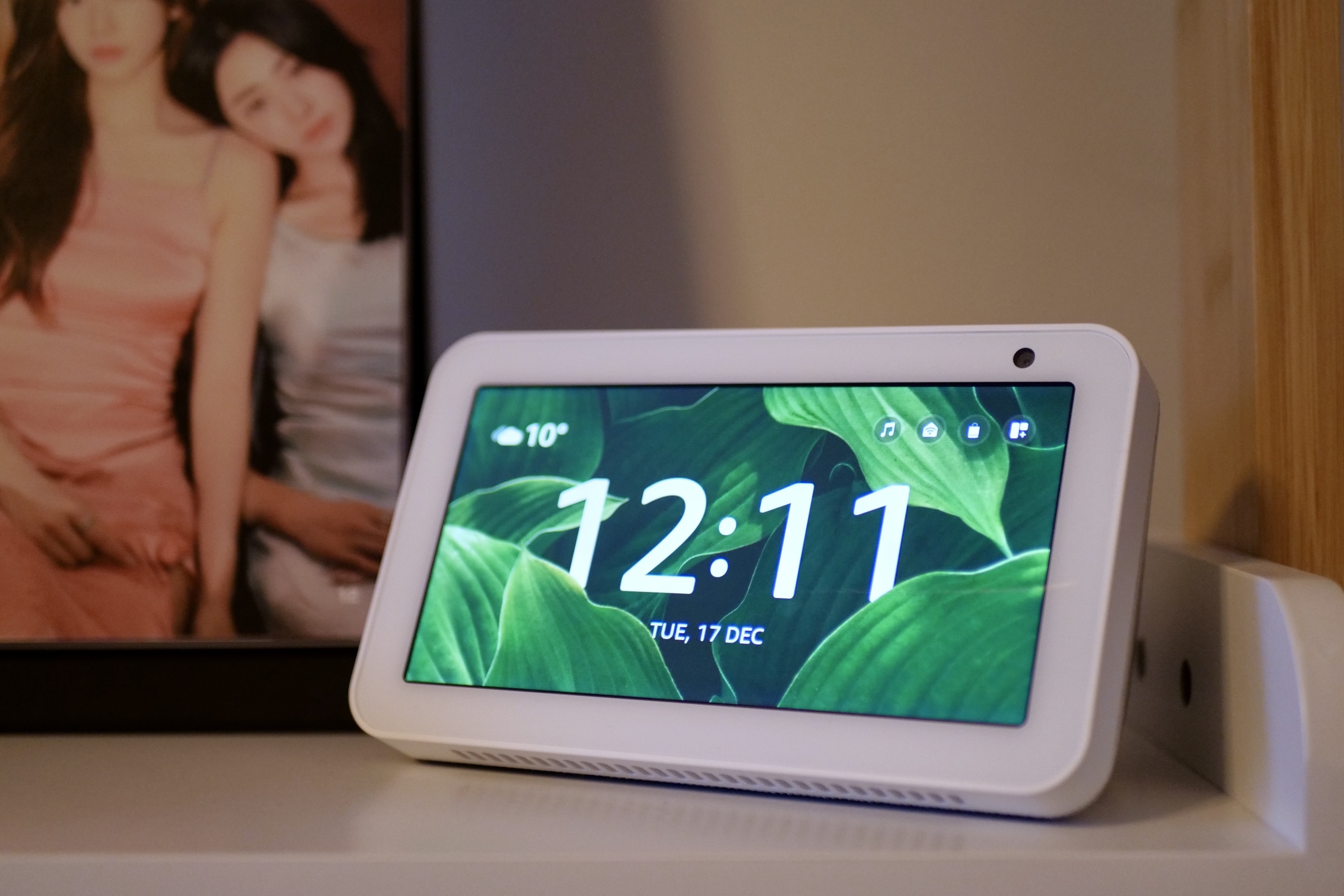 alt: An Amazon Echo Show 5 smart display positioned on a shelf.