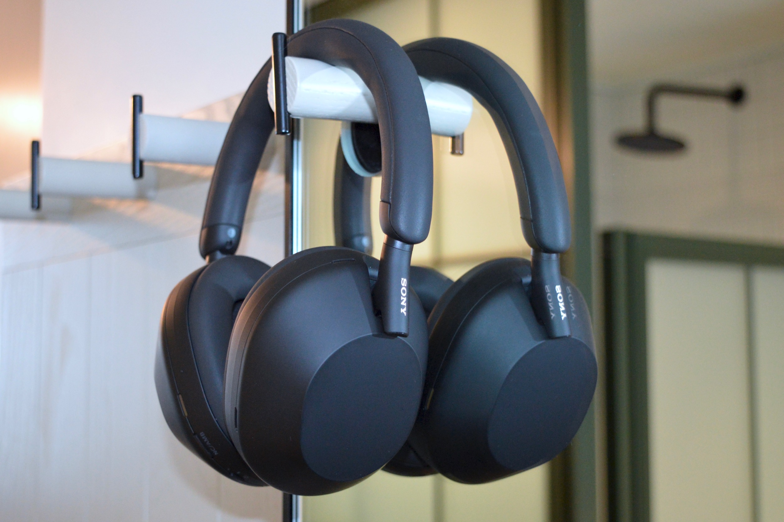 Sony WH-1000XM5 wireless noise-canceling headphones hanging on a wall hook