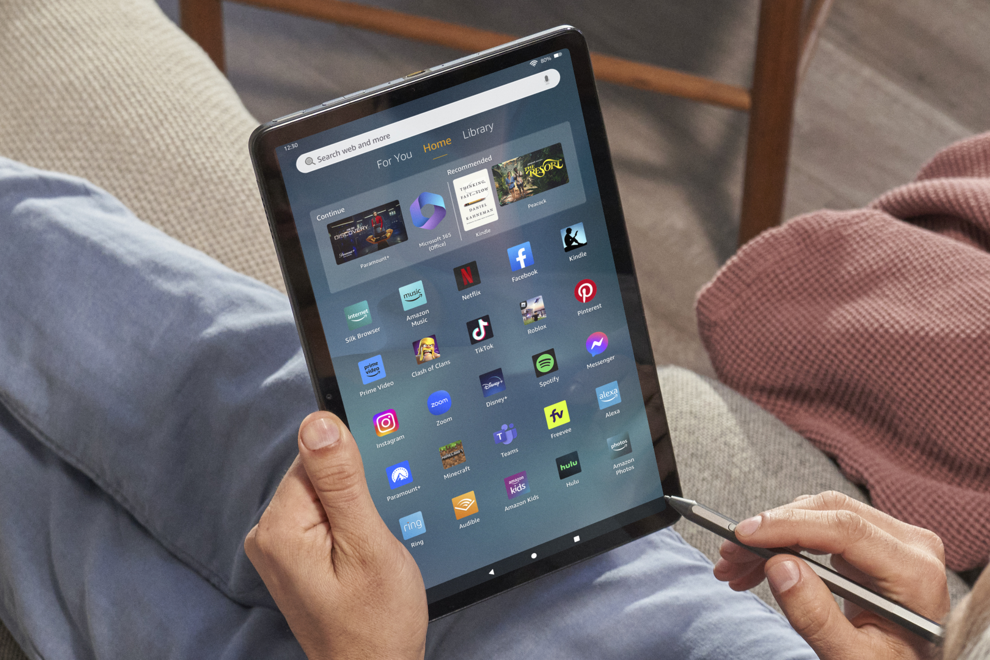 User holding the sleek Amazon Fire Max 11 tablet displaying its interface