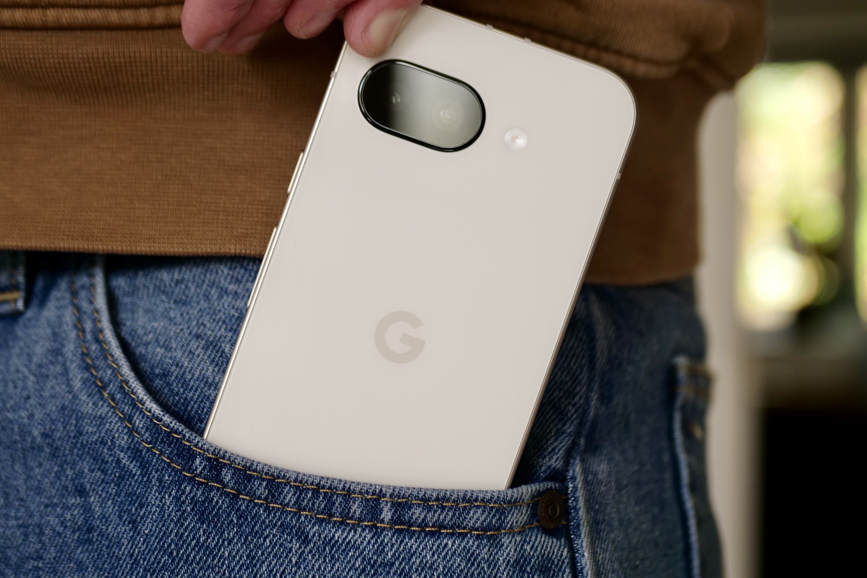 Google Pixel 9a being conveniently taken from a pocket, highlighting its accessibility as an affordable Razr 2025 alternative.