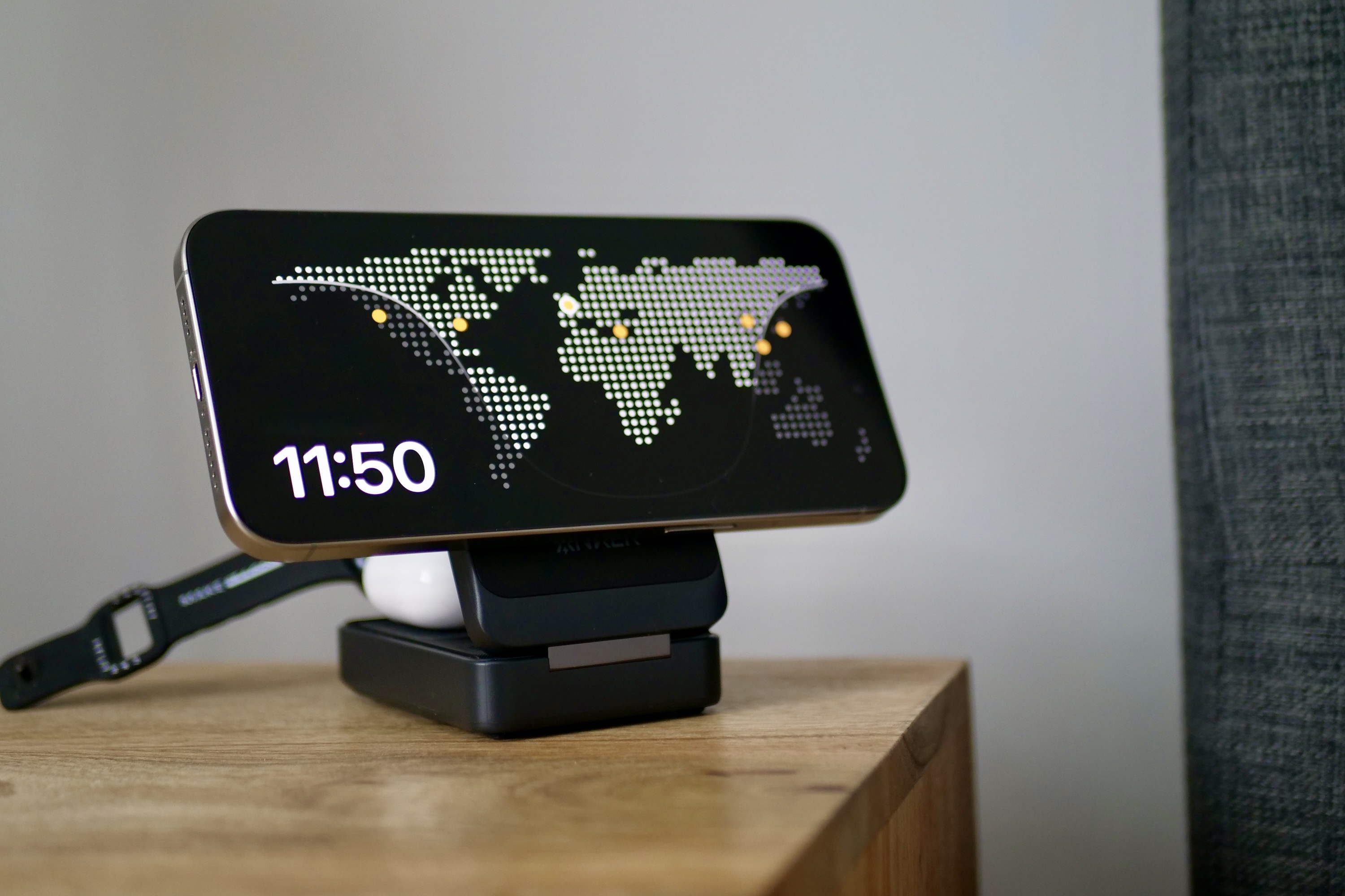 The iPhone 15 Pro Max in Standby mode resting on an Anker MagGo Wireless Charging Station, showcasing landscape orientation utility.