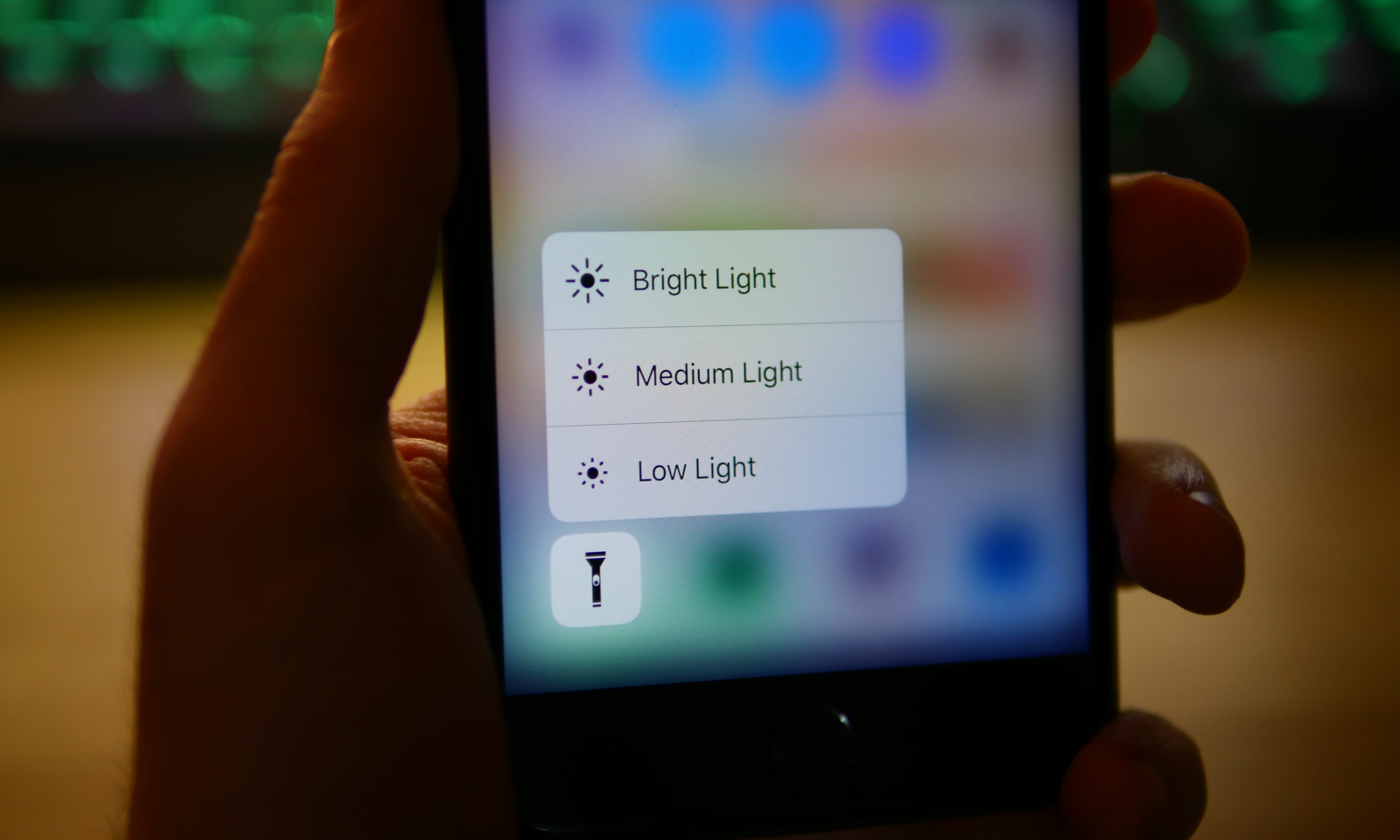 Demonstration of 3D Touch being used to access flashlight intensity controls on an iPhone.