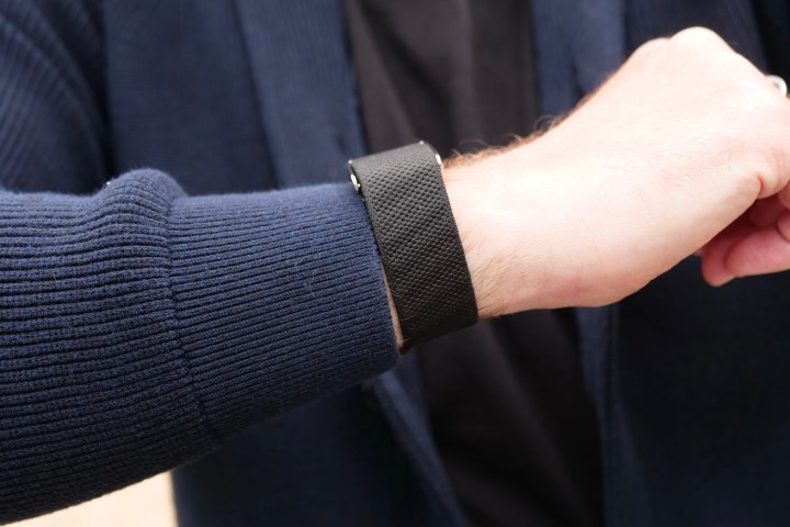 Whoop 5.0 fitness band worn on a wrist, showcasing its black fabric strap and central module.