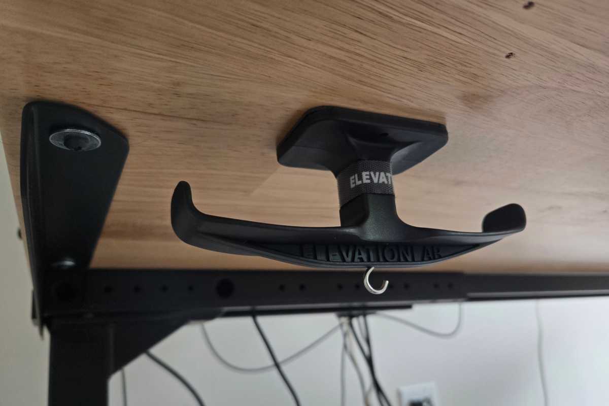 Close-up of the Elevation Lab AnchorPro dual hook mounted discreetly under a wooden desk using its strong adhesive.