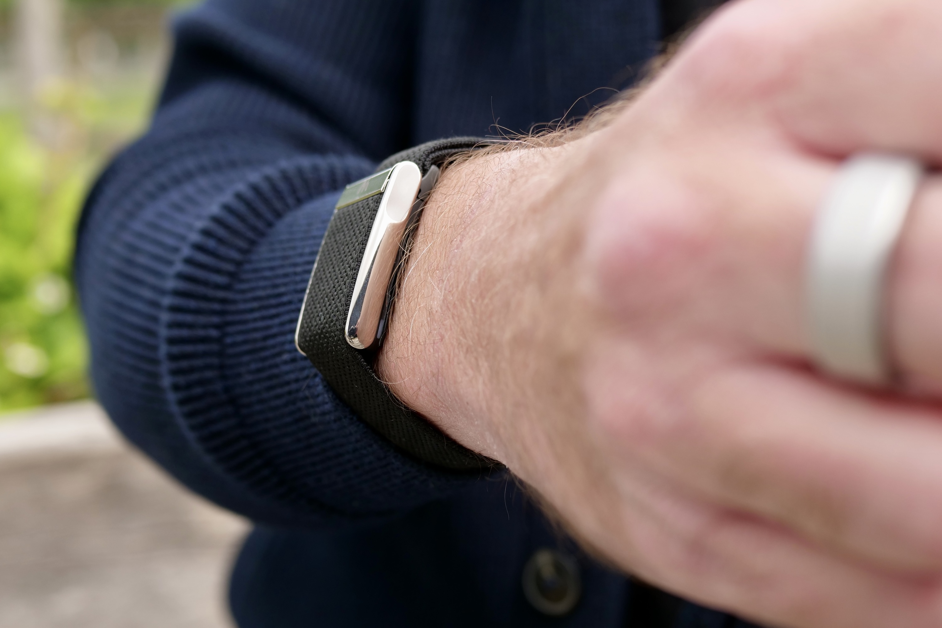 Side profile of the Whoop 5.0 wearable tracker on a wrist, highlighting its slim, screen-less design contributing to extended battery life.
