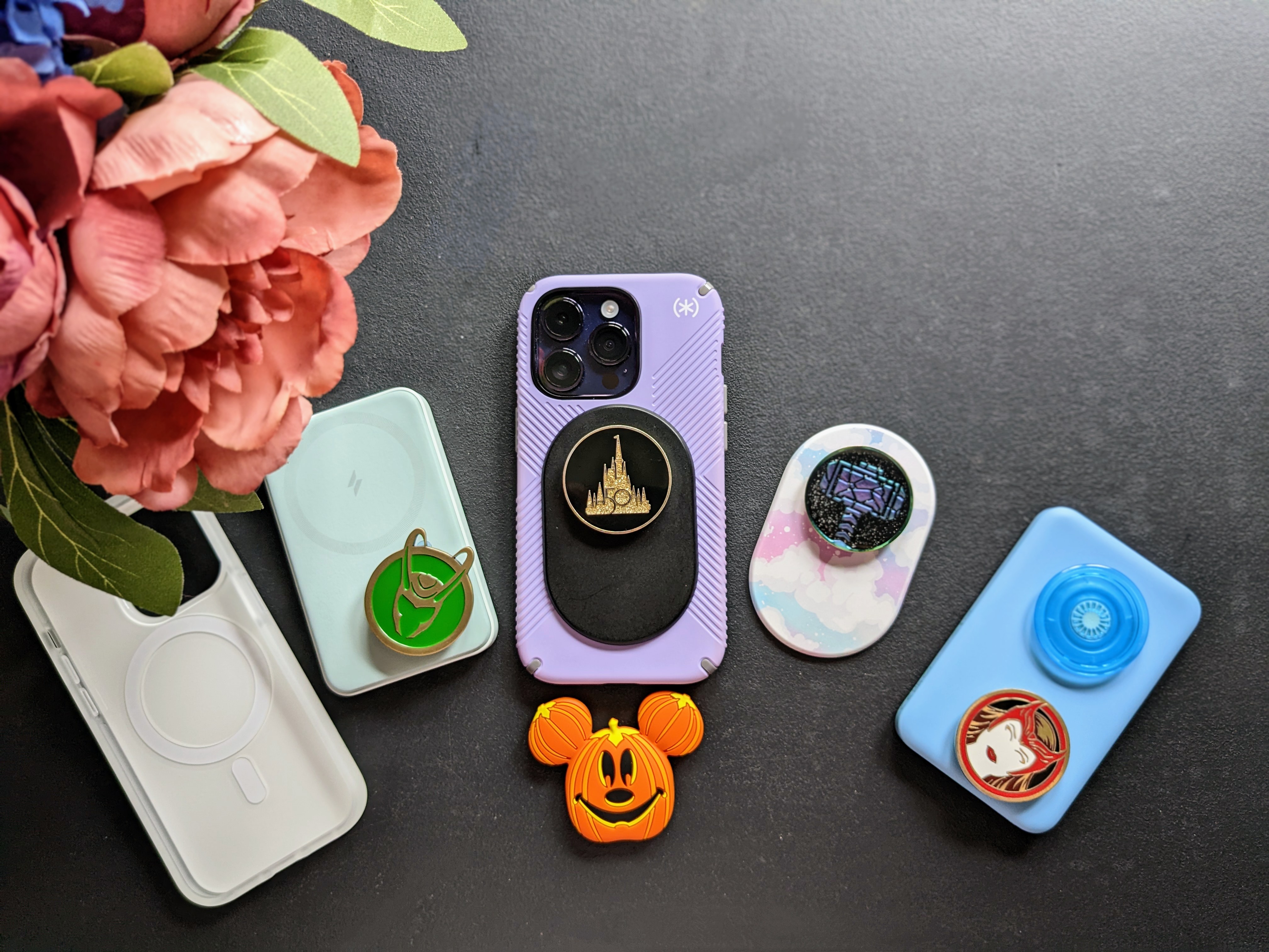 iPhone 14 Pro with MagSafe accessories like PopSocket and battery packs.