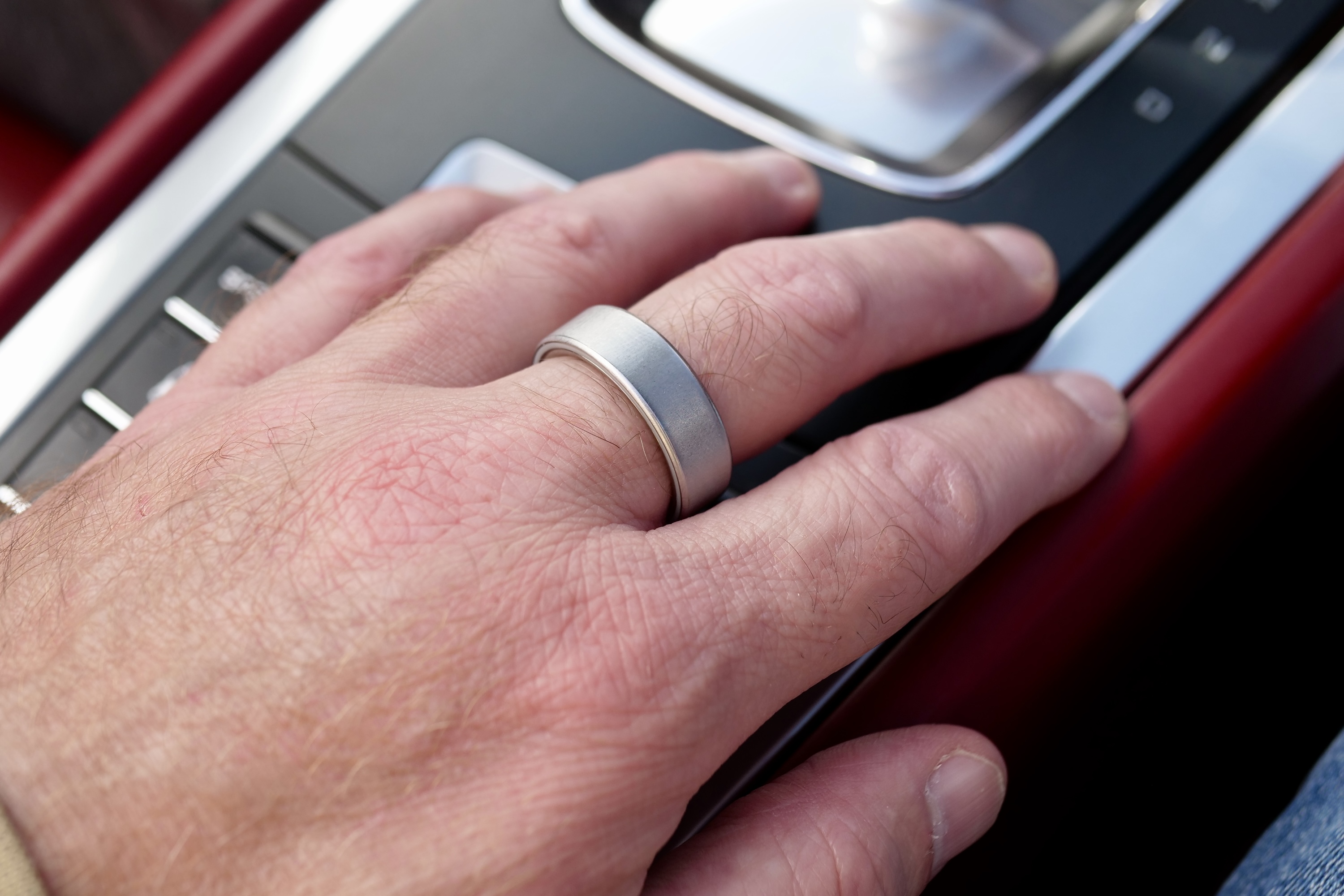 A person's hand showing the Oura Ring 4 worn on a finger, highlighting its discreet style.