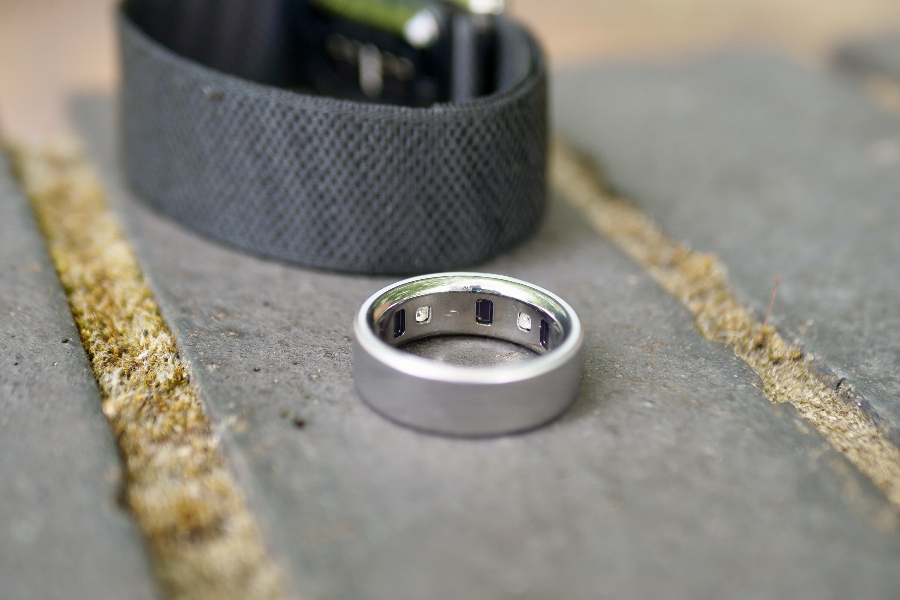 The Whoop 5.0 fitness band and the Oura Ring 4 smart ring displayed side-by-side for comparison.