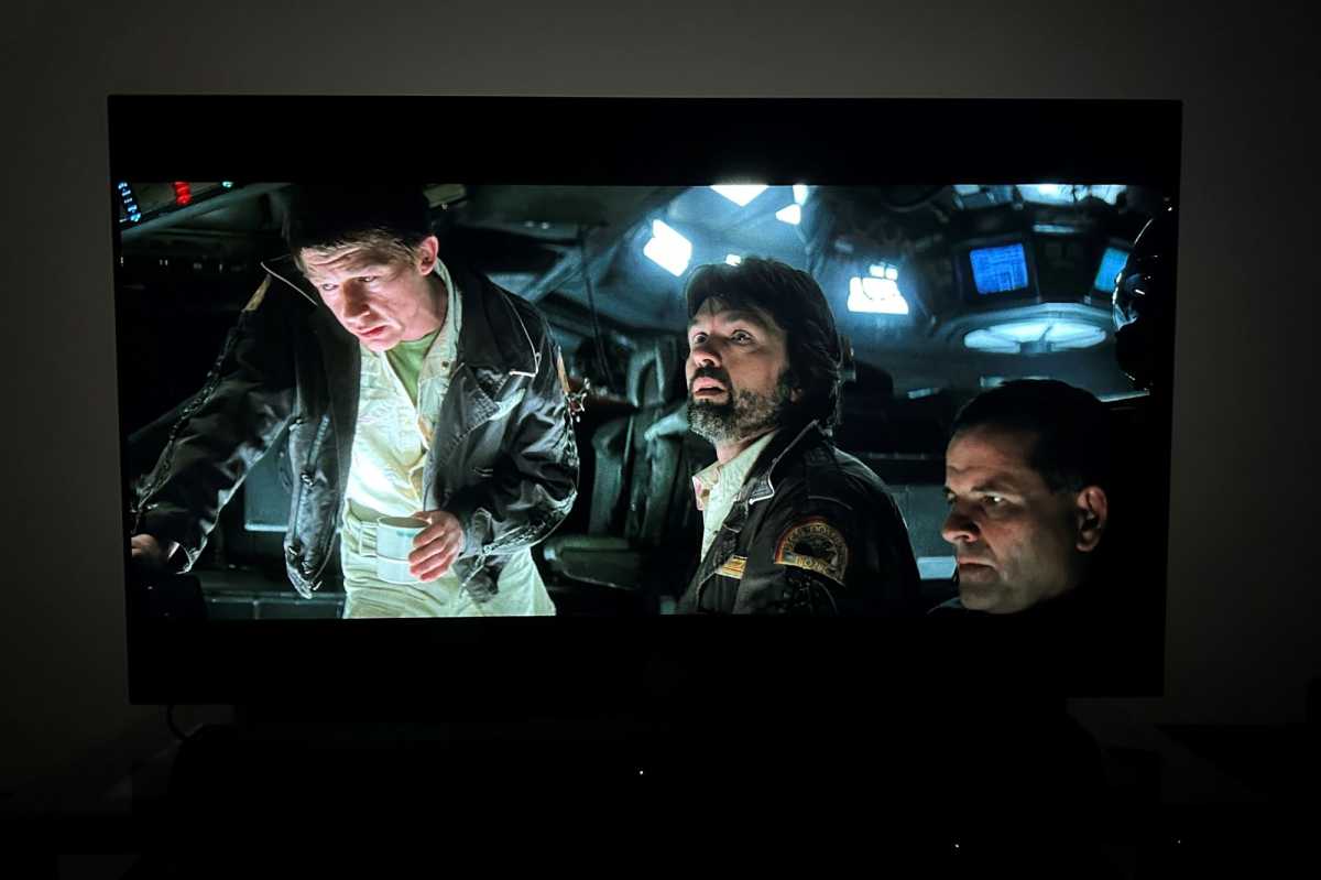 A 6500K LED bias light strip subtly illuminates the wall behind a TV in a dark room, enhancing picture quality.