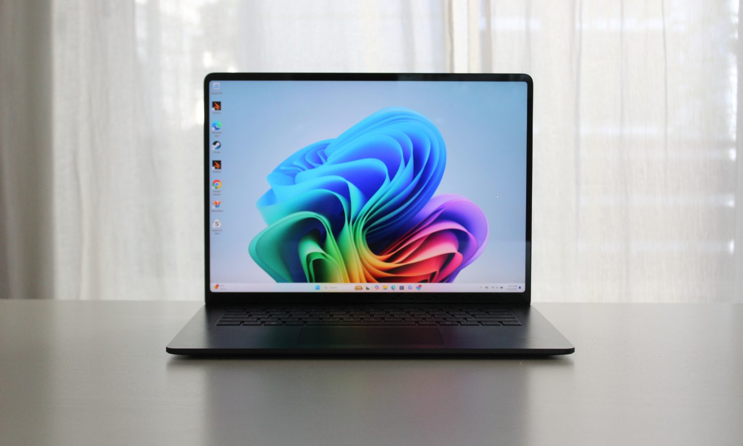 The Surface Laptop 7 on a table in front of a window.