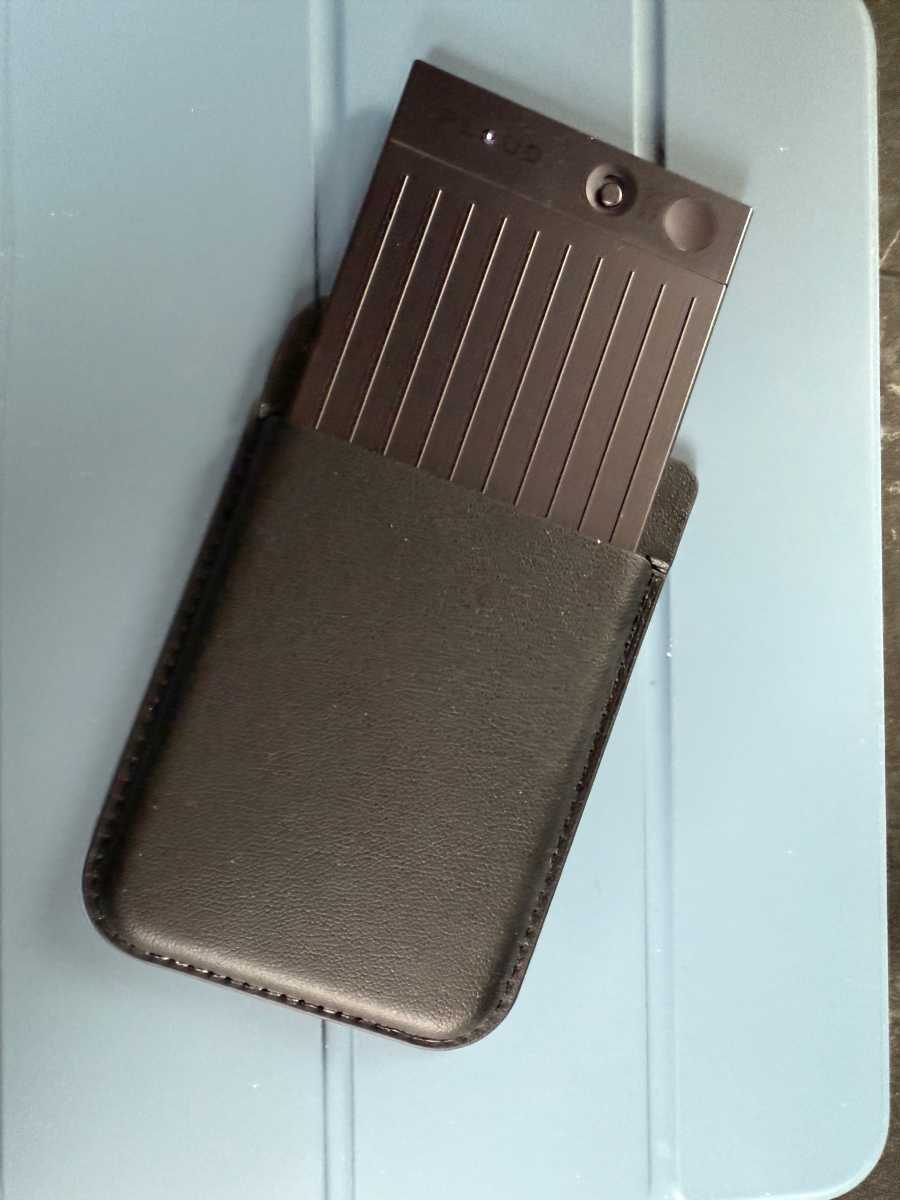 Sleek black Plaud Note AI voice recorder next to a smartphone displaying its app interface.