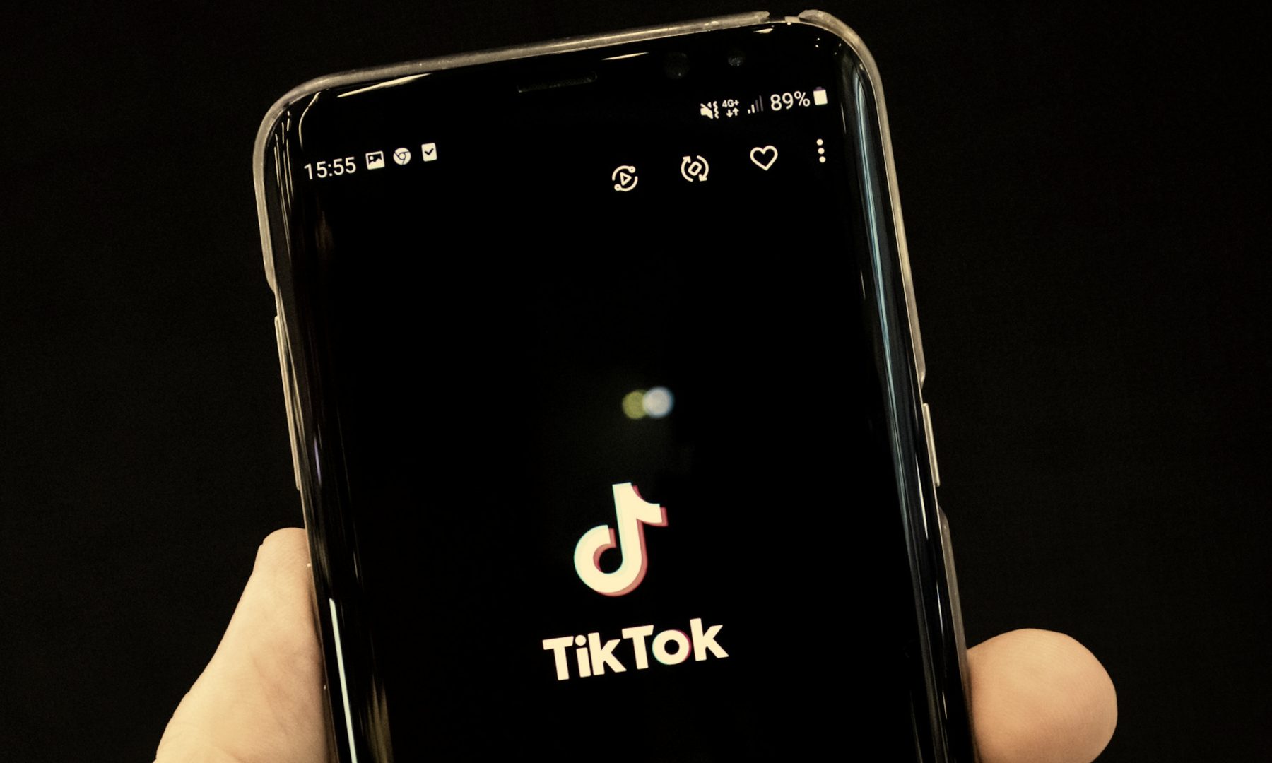 alt text: TikTok splash screen displayed on an Android smartphone.