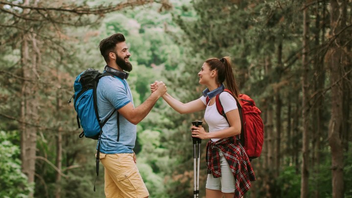 man and woman hiking and shaking hands