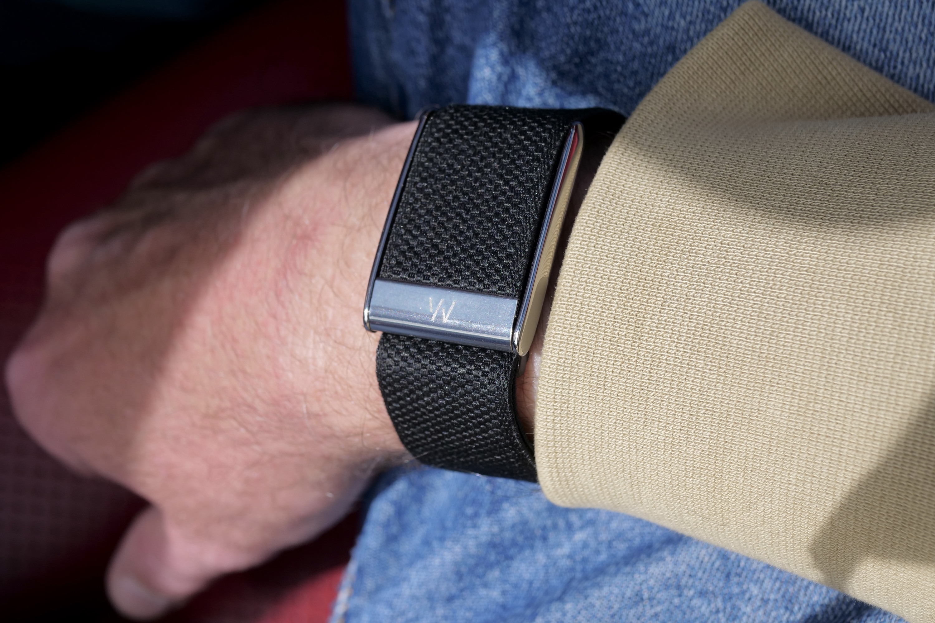 A person wearing the Whoop 5.0 fitness band on their wrist, showcasing its design.