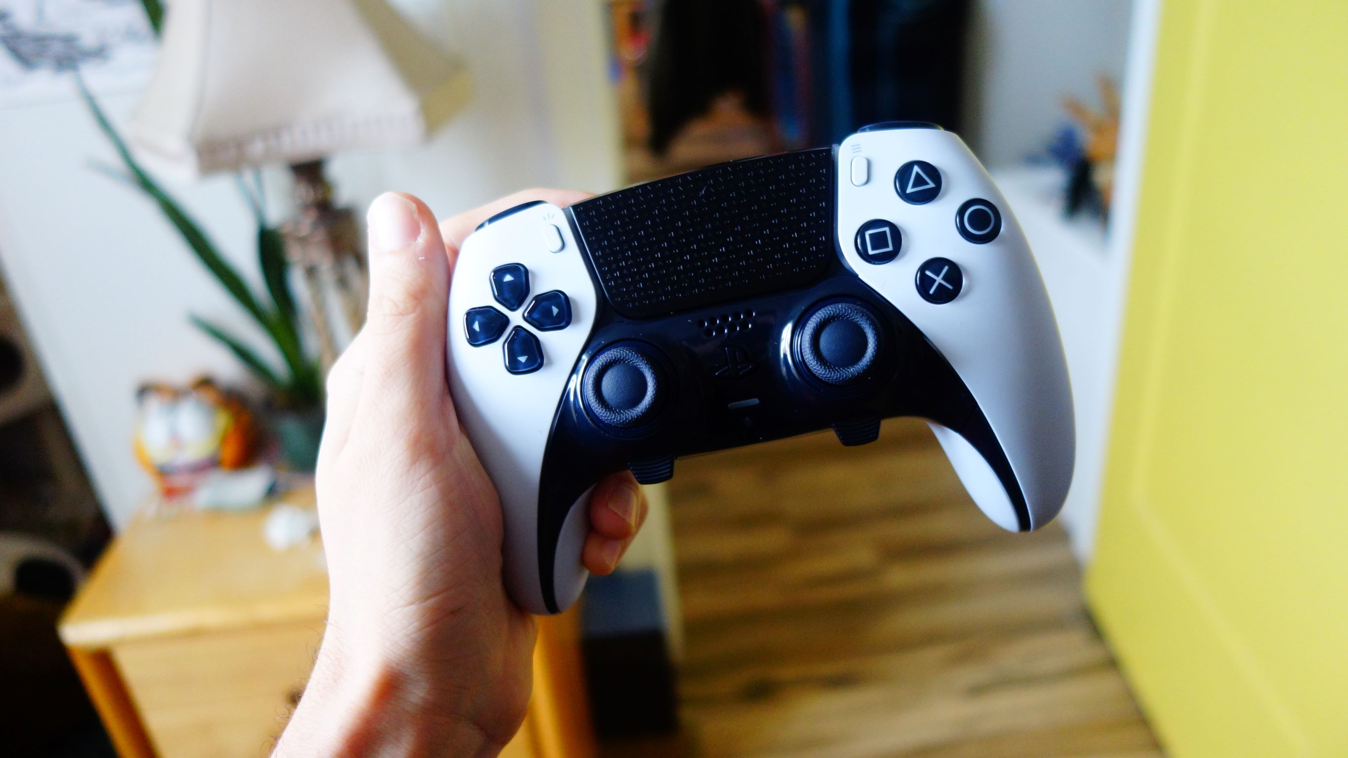Hand holding the customizable PlayStation DualSense Edge wireless controller for PS5 gaming.
