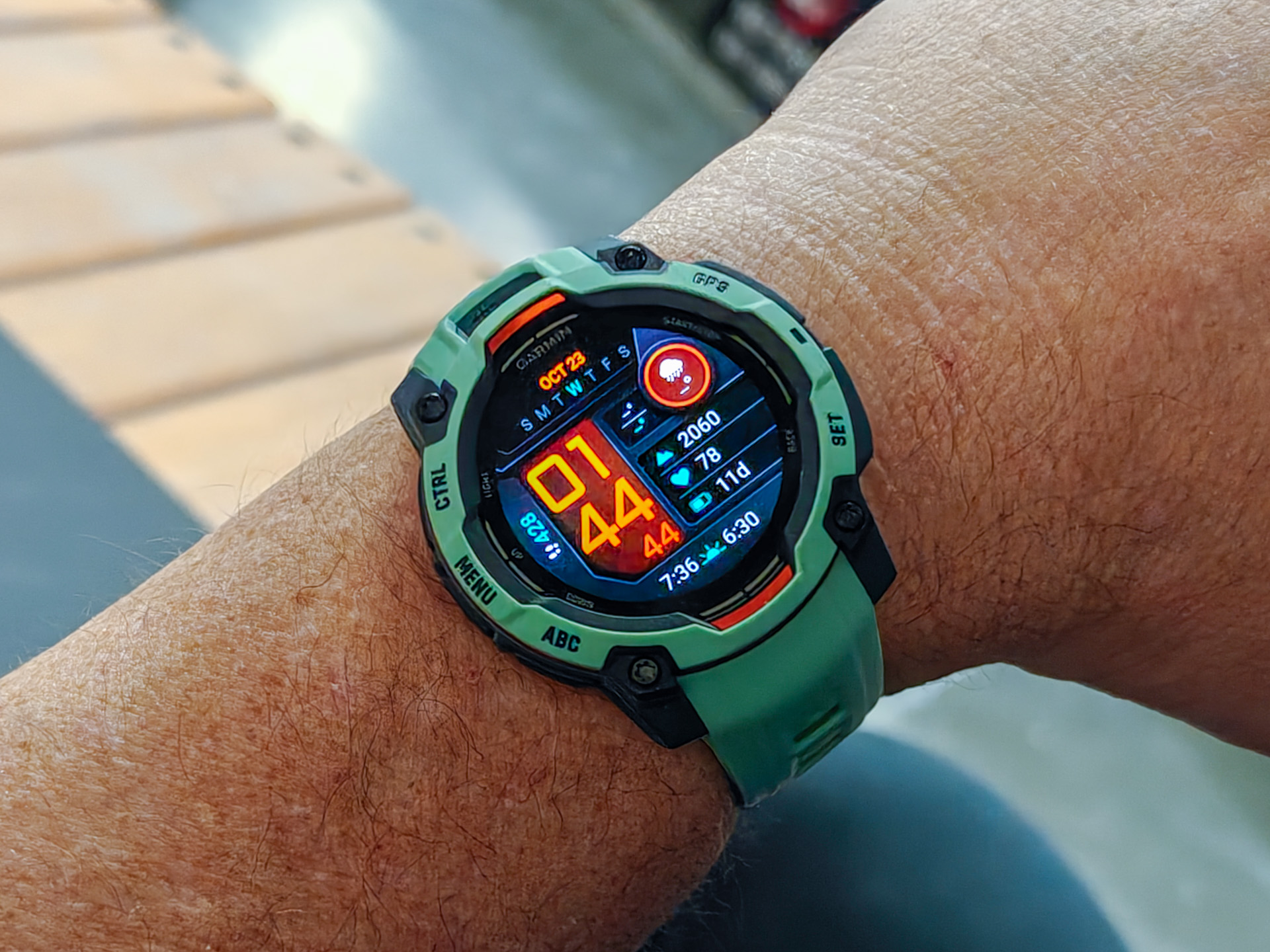 Garmin Instinct 3 rugged smartwatch displaying its AMOLED home screen with fitness data.