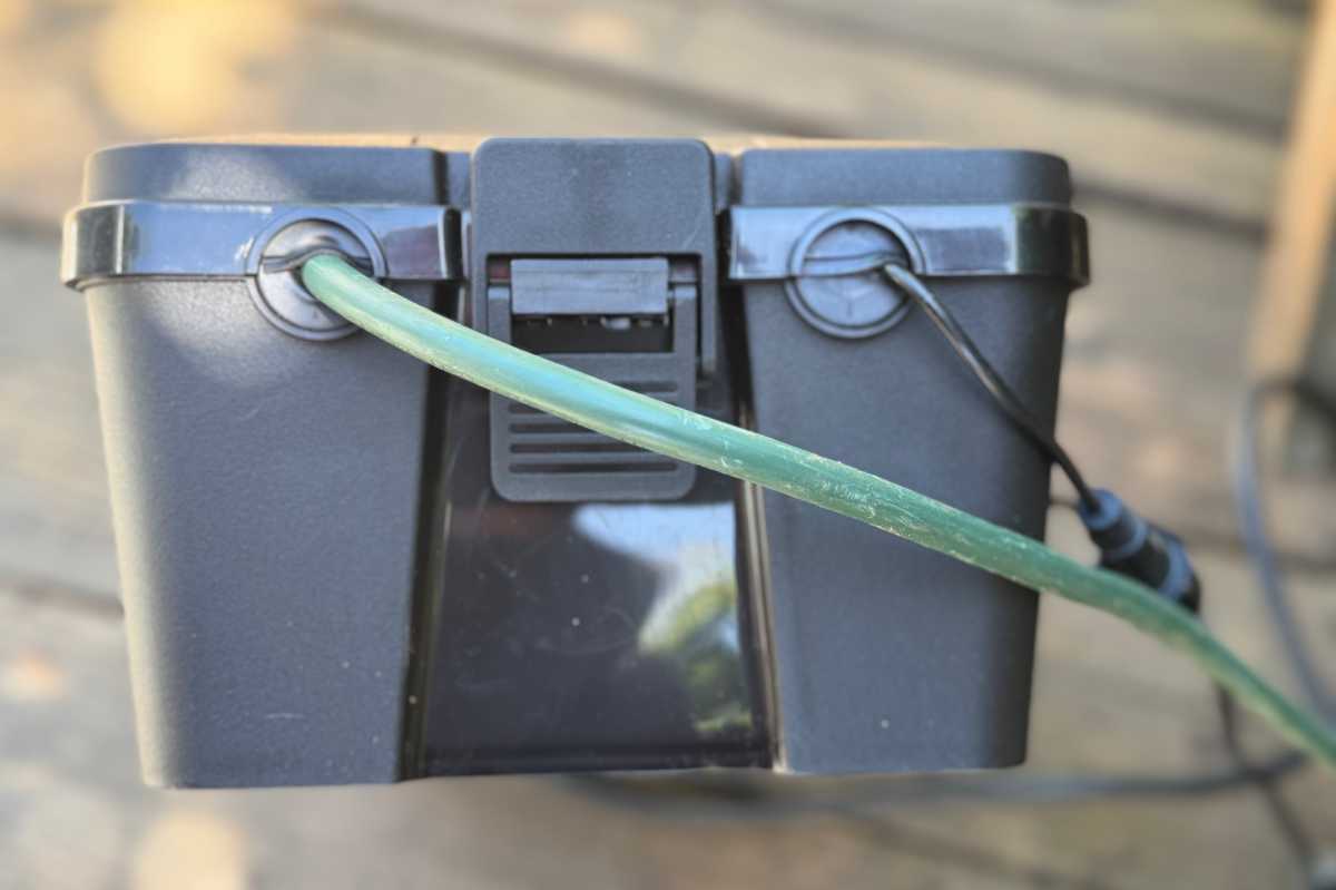 Close-up of cables entering the Iwillink outdoor electrical box, secured by latches and silicone seals to prevent water ingress.