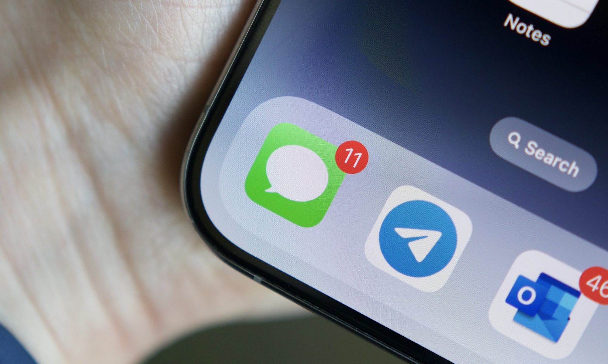 Close-up of the Apple Messages app icon on an iPhone screen, hinting at new iOS 26 messaging features.