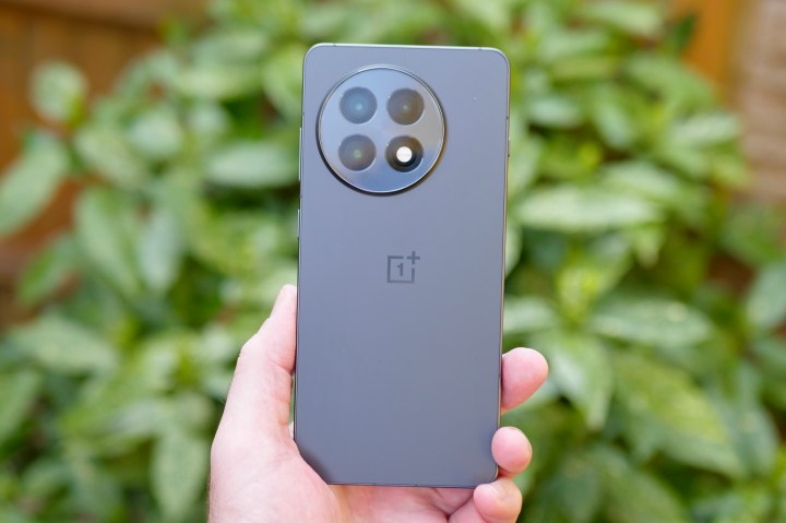 Person holding the OnePlus 13R, displaying its screen and ergonomic design.