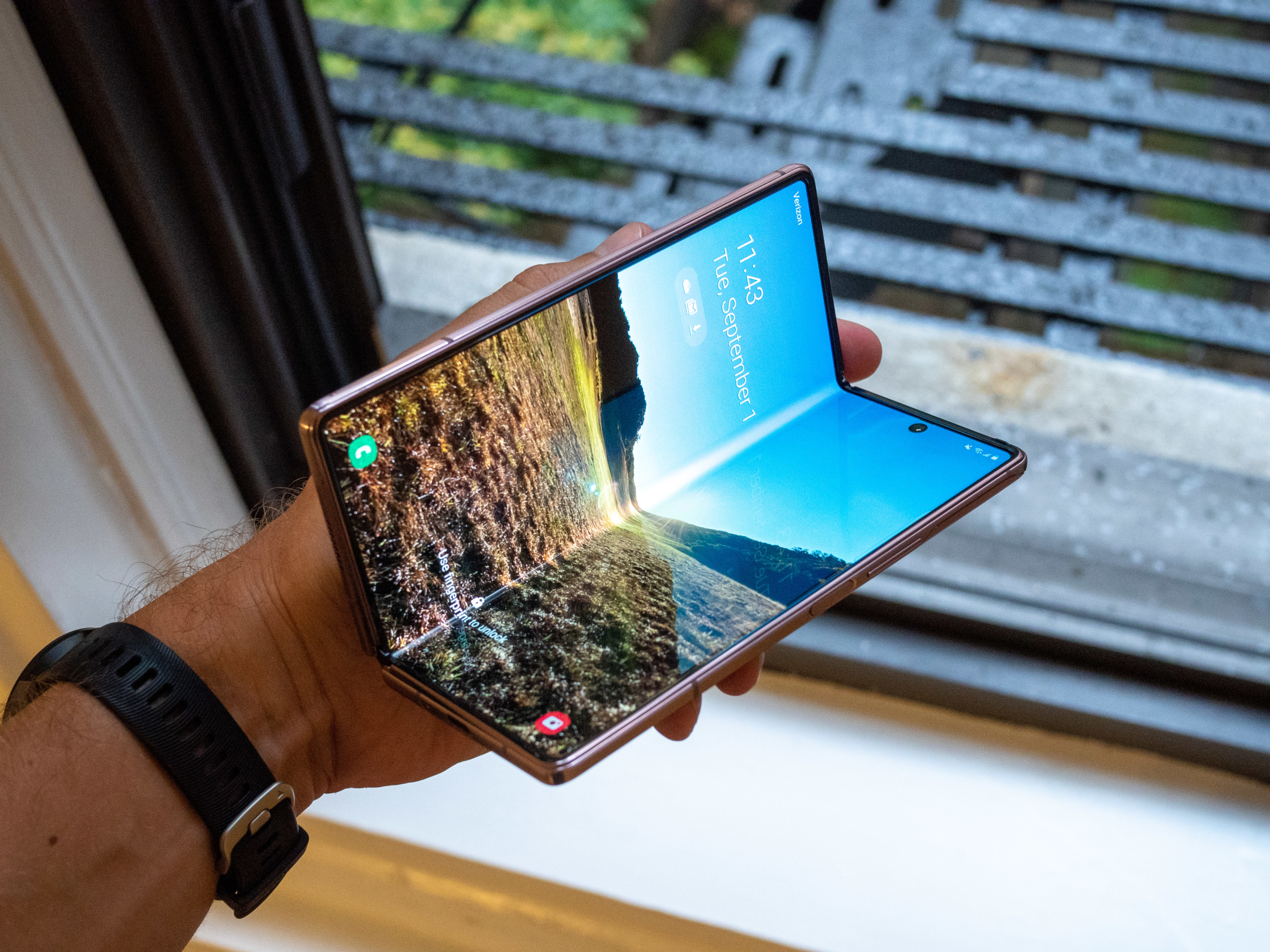 Hand holding a Samsung Galaxy Z Fold 2, illustrating early foldable phone design challenges.