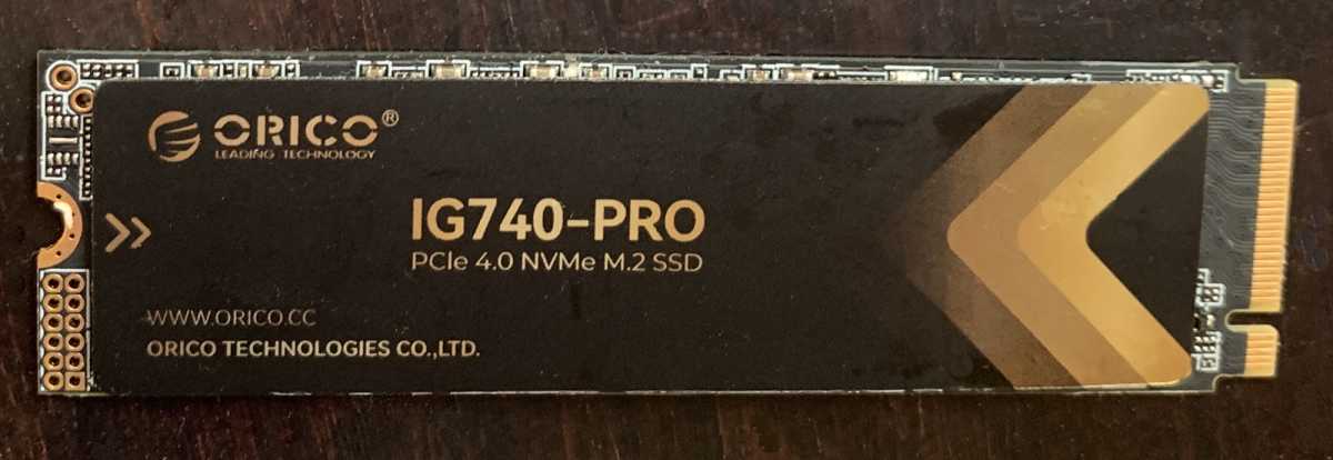 Orico IG740-Pro SSD with included heat spreader and screwdriver kit displayed on a surface.