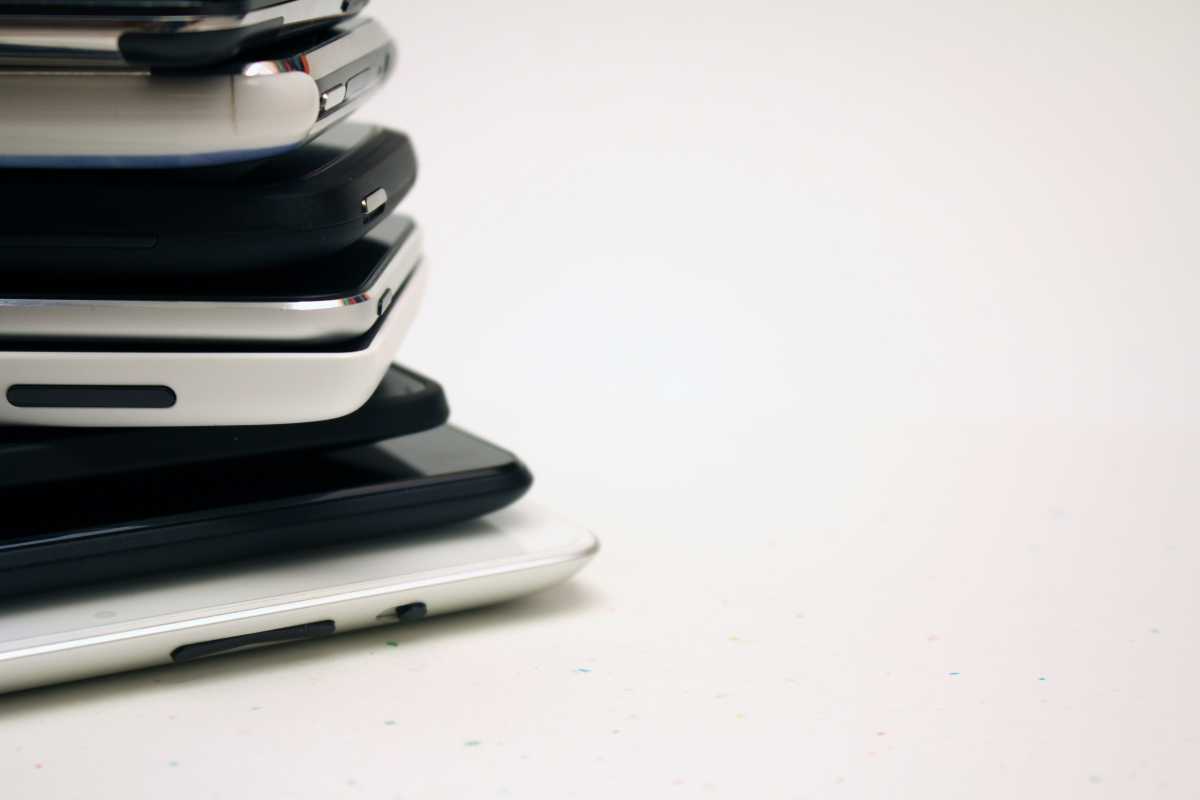 A towering stack of various electronic devices illustrating tech clutter before digital simplification for better security.