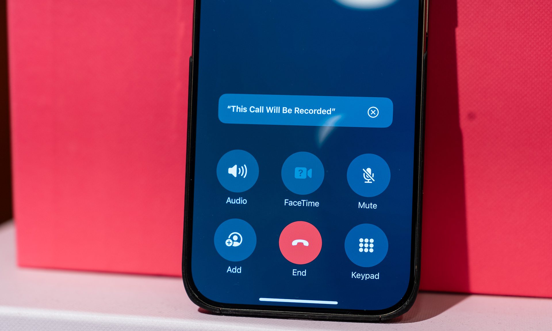 iPhone 16 Pro displaying an iOS 26 Apple Intelligence prompt for call recording and summarization in the Phone app.